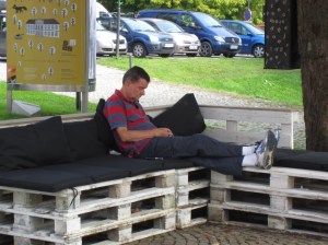 J (resting) waiting for K to exit the museum on a thoughtfully cushioned bench 